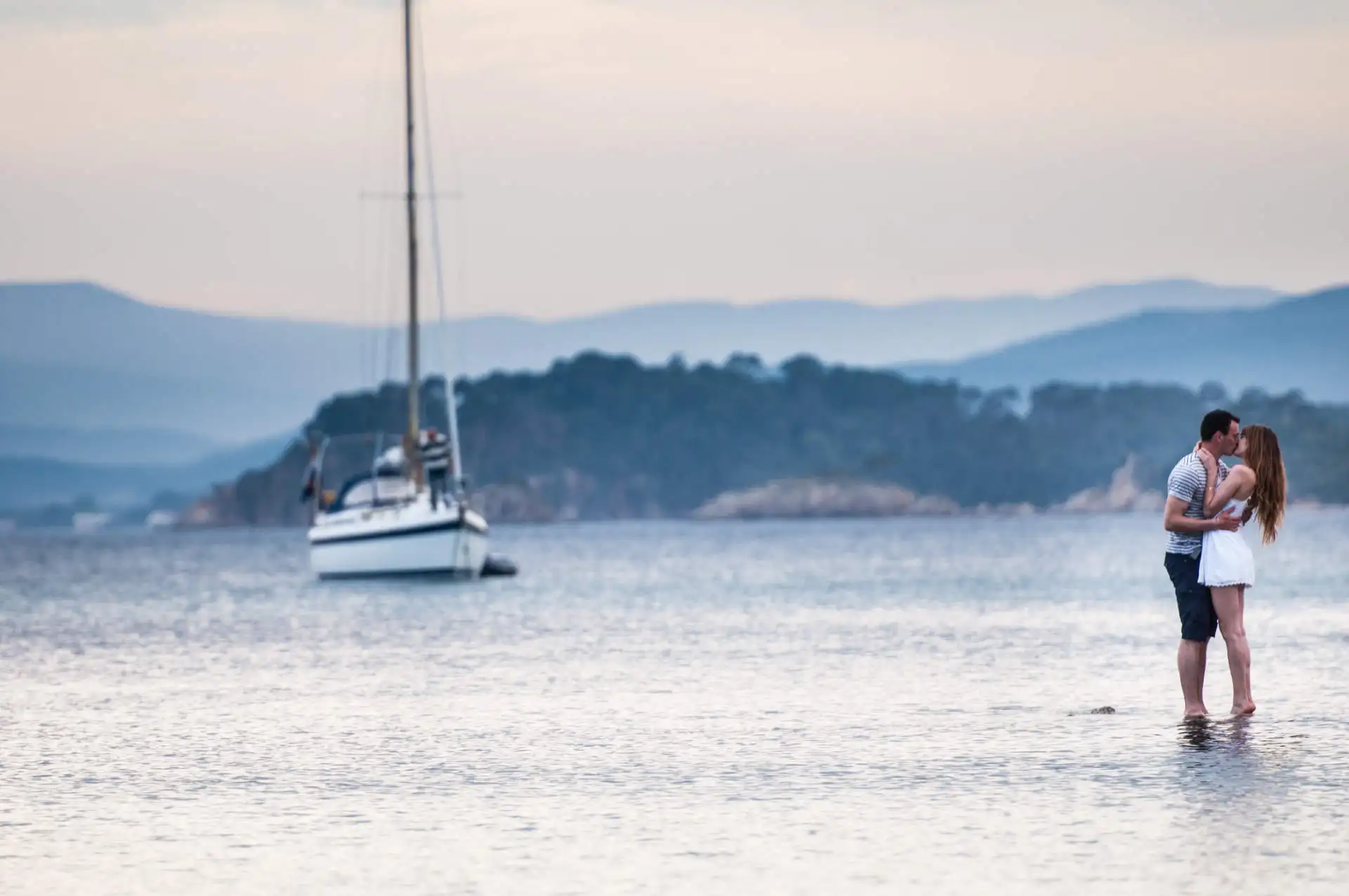 why preparing an engagement session is essential before marriage - Mathilde et Pierre couple engagement session - engagement at Fort de Bregançon - French Riviera engagement session on the sea with a boat in background - the couple is floating on the water while the man is proposing